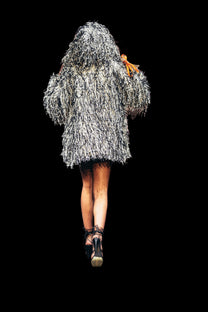 Model walking on a runway wearing a textured silver dress.